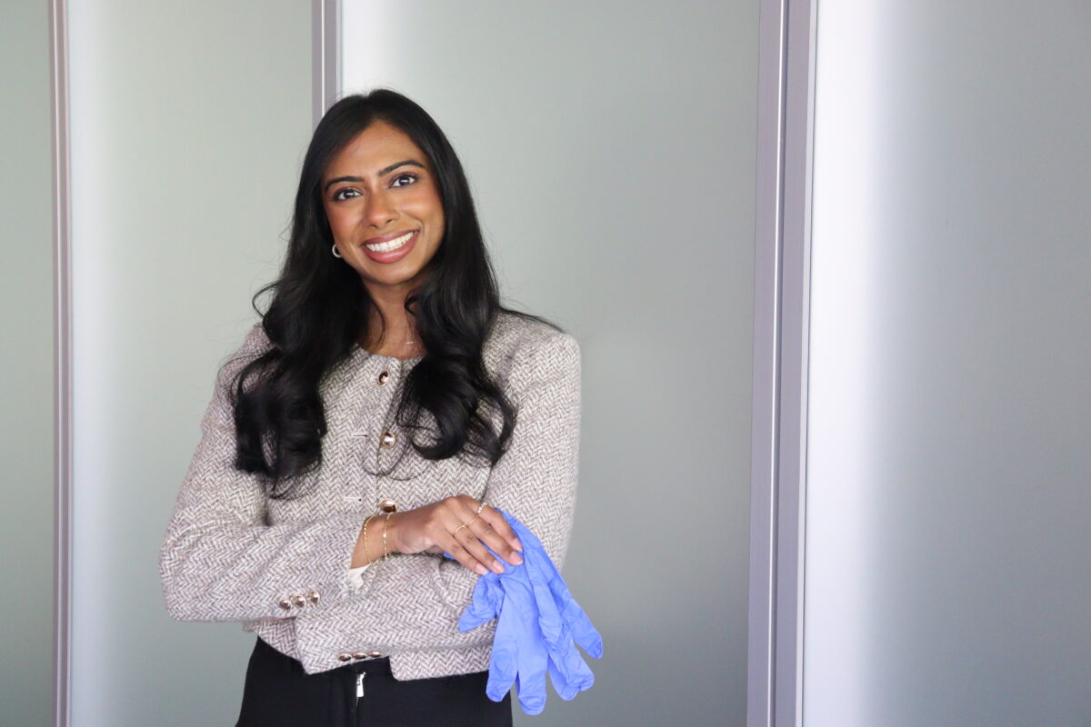 Navisha Weersinghe holding a pair of blue medical gloves